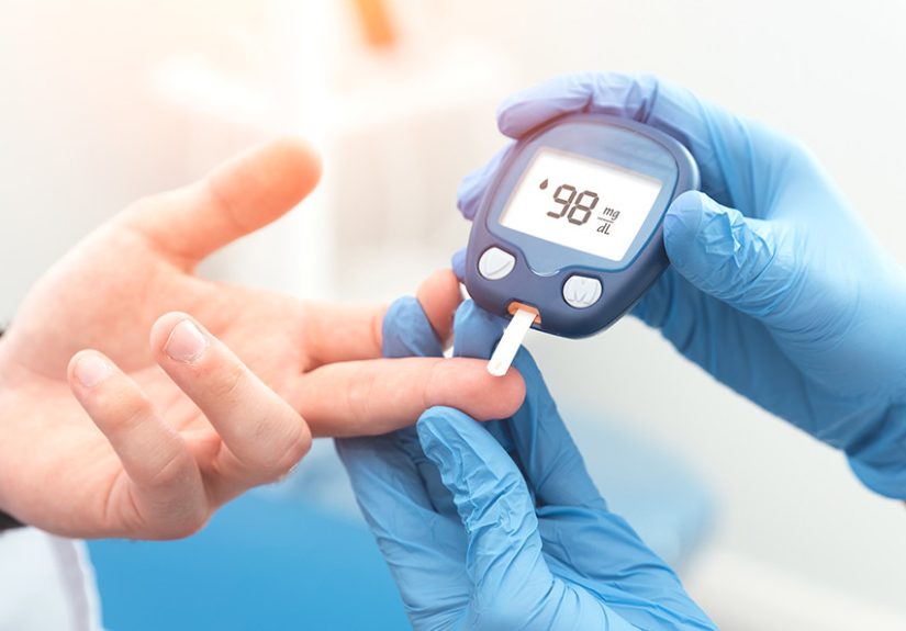 Doctor checking blood sugar level with glucometer
